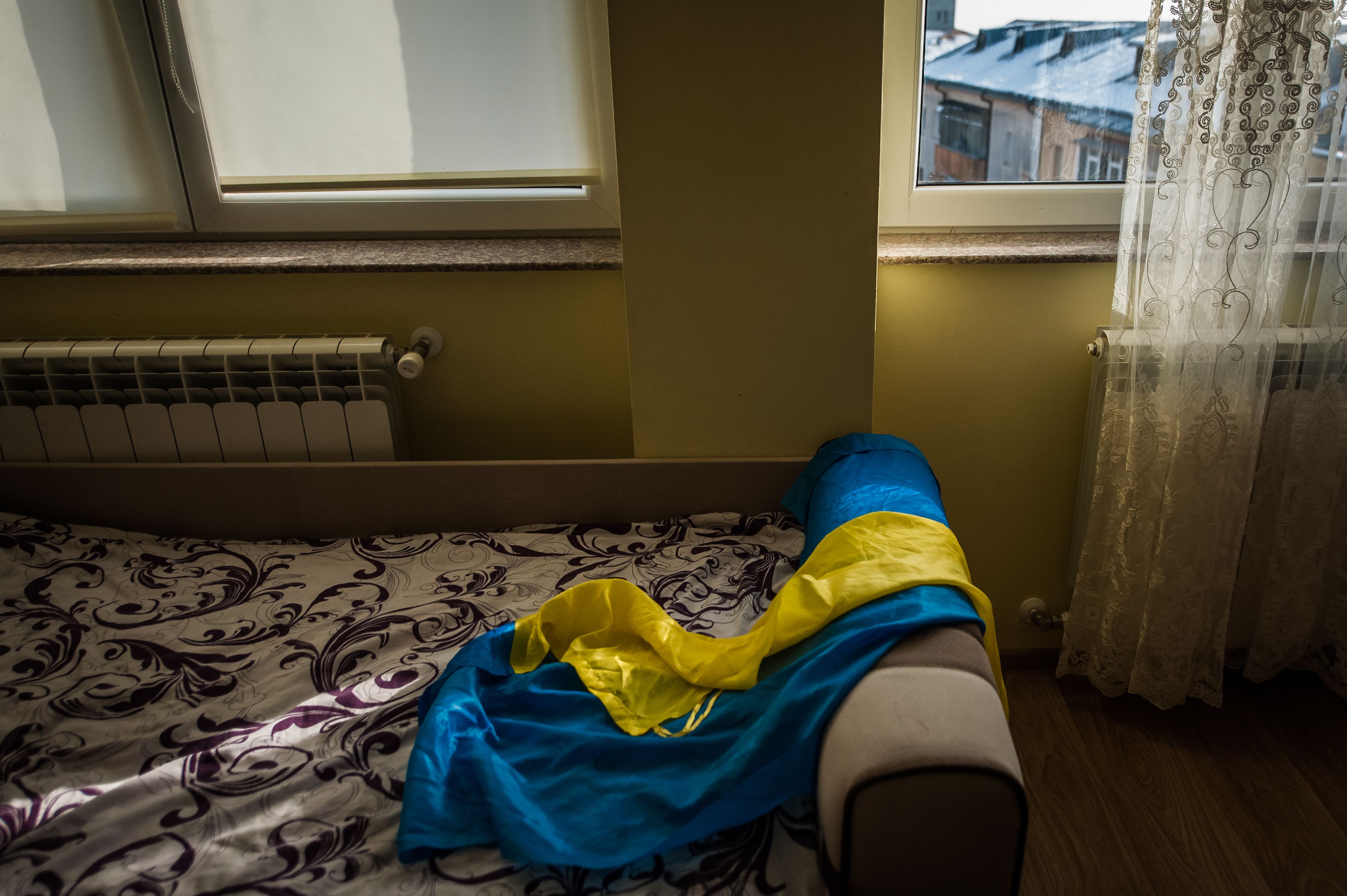 The Ukrainian flag lays on the bed in Elena's home in Suceava county, northern Romania.